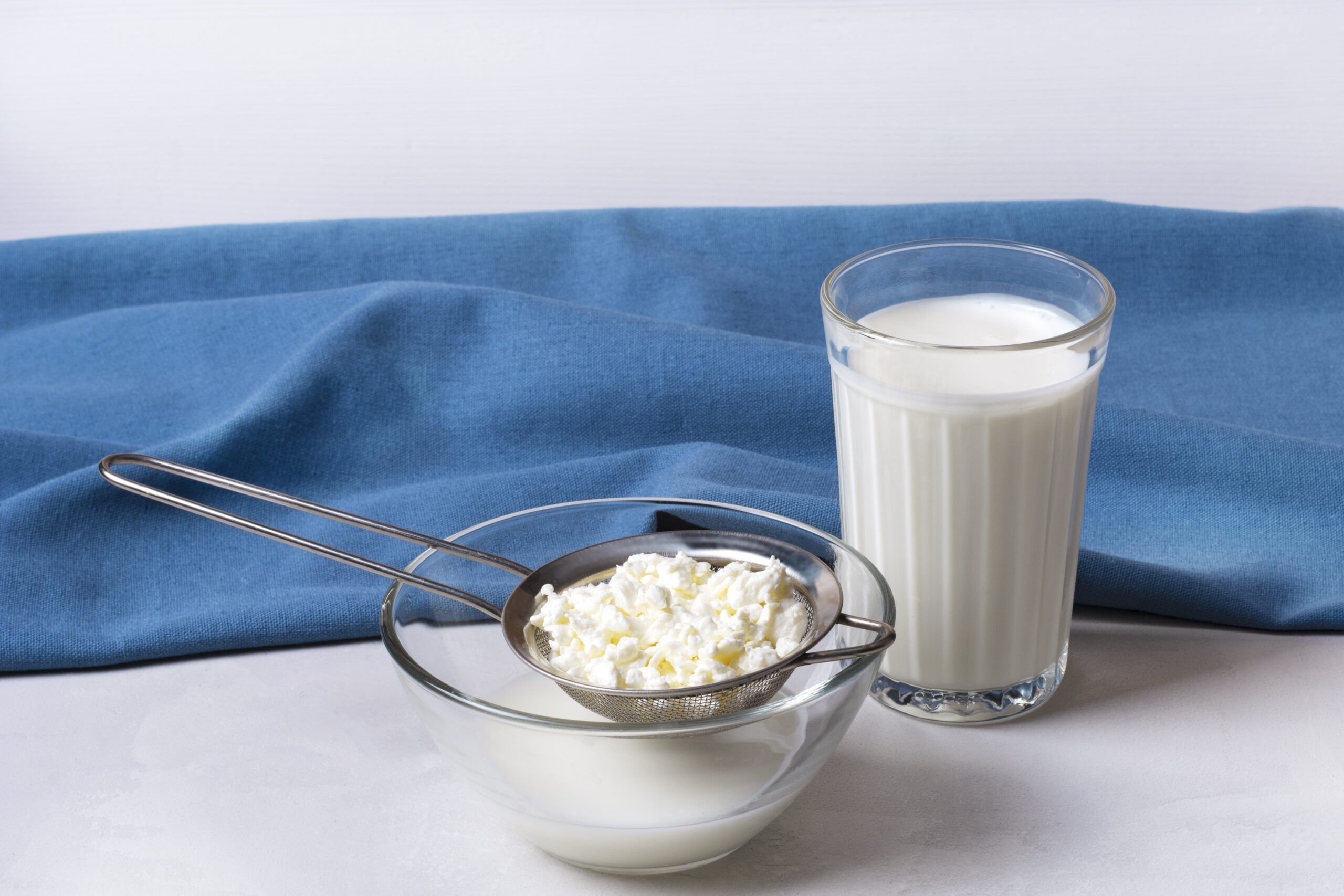 Kefir fermented milk drink with kefir grains. Homemade kefir stands in a glass, next to kefir grains in the background. Horizontal orientation. The concept of proper nutrition. Bulgarian drink.